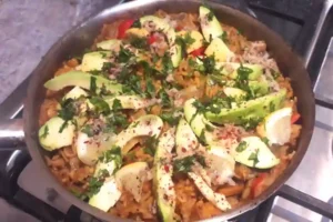 spanish paella mexican style, topped with acodaco, coriander leaf and lime