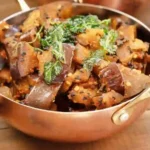 bengali aubergine bhaji served in a copper bowl with brass handles