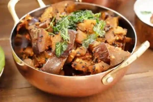 bengali aubergine bhaji served in a copper bowl with brass handles