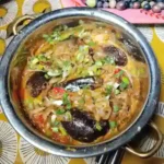aubergine do pyaza served with in a traditionl indian copper pot