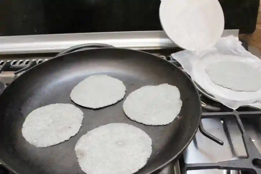 making tortillas on a cast iron skillet made from blue corn masa harina
