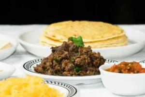 refried black beans recipe: served on a white dish with yellow corn tortillas